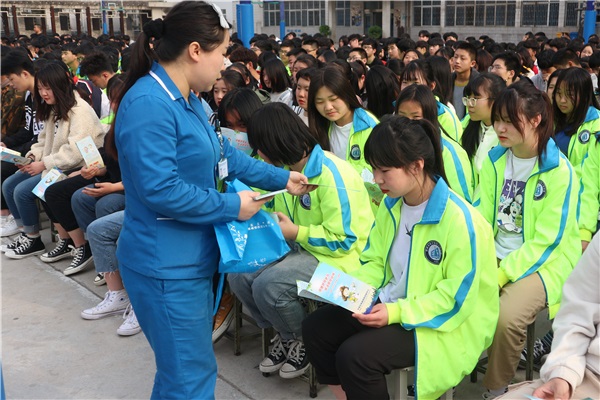 工作人員為學(xué)生分發(fā)傳染病防治知識(shí)手冊.JPG