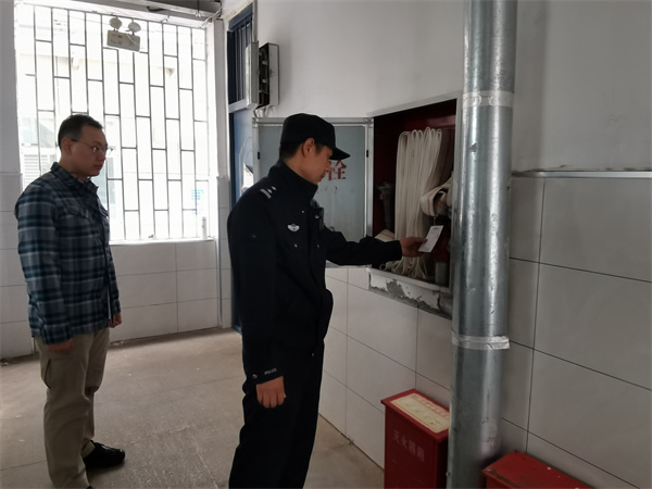 圖為郭警官檢查學(xué)校消防設(shè)施.jpg