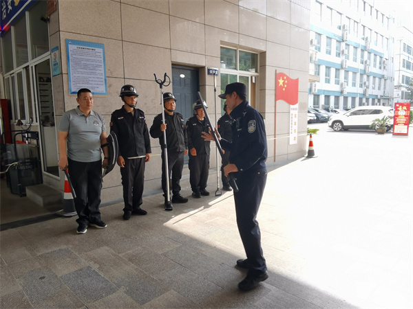 圖為郭文瑞警官向?qū)W校安保人員教授安保器械使用方法.jpg